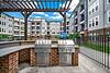 Outdoor grilling area with two BBQ grills near an apartment complex.