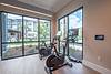 A modern fitness area with two stationary bikes and large windows overlooking a courtyard.