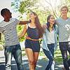 A group of young friends enjoying a walk outdoors, laughing and having fun together.