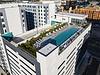 Aerial view of apartment building with a rooftop pool and lounge chairs.