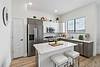 Modern kitchen with stainless steel appliances and white cabinetry.