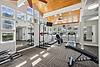 Bright and spacious gym with various exercise equipment and ample natural light.