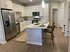 Modern kitchen with stainless steel appliances and a clean, open layout.