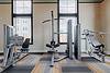 A modern gym space with various workout machines and equipment.