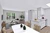 Modern apartment with a living area, dining table, and kitchen.